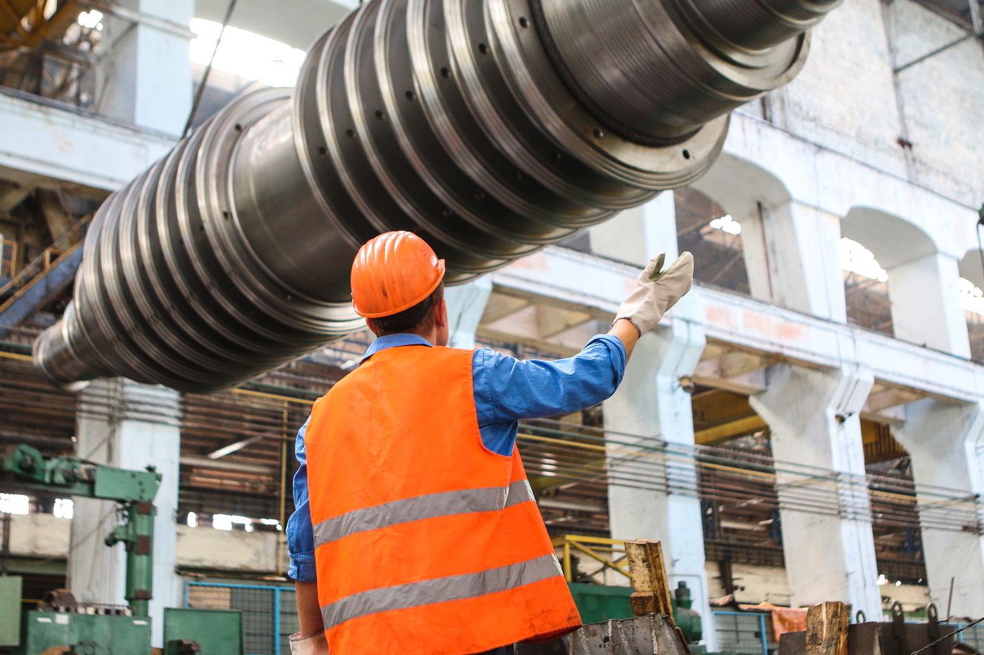 Engineer inspecting a large machined downhole tool